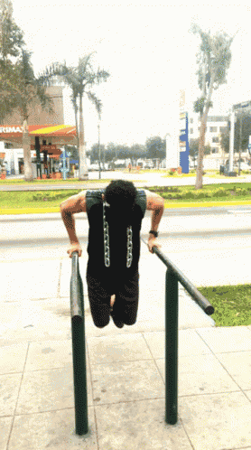 a man is doing push ups in front of a gas station that says optima
