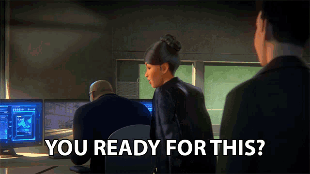 a man and a woman are standing in front of computer monitors with the words " you ready for this "