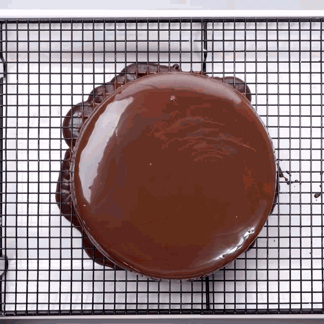 a chocolate cake is sitting on a cooling rack on top of a wire rack