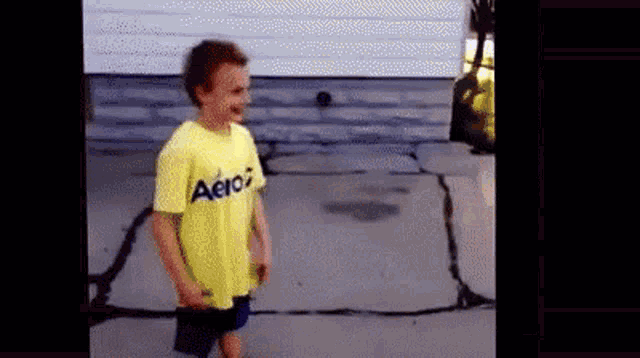 a young boy wearing a yellow shirt that says aeropostale