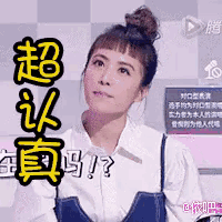a woman with her hair in a bun is sitting in front of a sign that says ' ? '