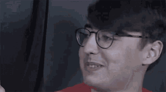 the man is wearing glasses and making a funny face .