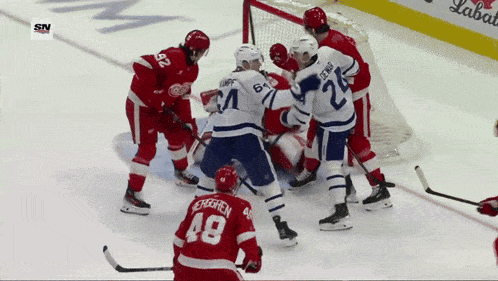 a hockey player with the number 48 on his jersey is surrounded by other players