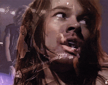 a close up of a person 's face with a guitar in front