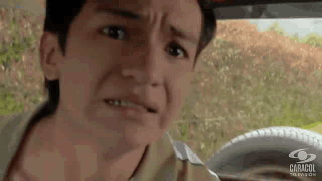 a young boy is making a funny face in a car with caracol television written on the bottom