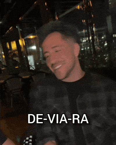 a man in a plaid shirt says de-via-ra on his face