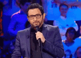 a man in a suit is speaking into a microphone