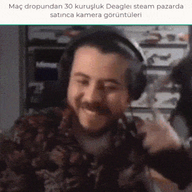 a man with a beard wearing headphones is smiling in a video