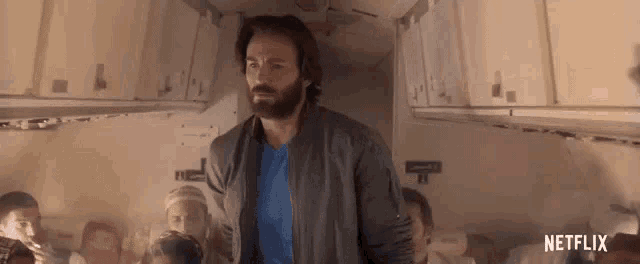 a man with a beard is standing in the middle of a plane .