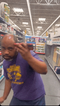 a man in a purple shirt that says minnesota is standing in a store