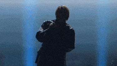 a man is standing in front of a microphone on a stage .