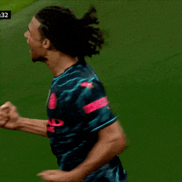 a soccer player wearing a black shirt with a pink x on the sleeve