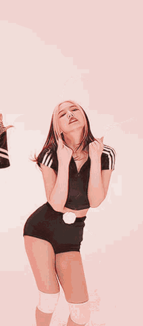a woman in a black top and shorts is dancing