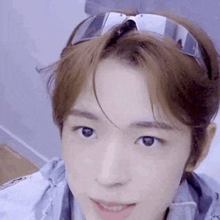 a young man wearing sunglasses and a headband is looking at the camera .