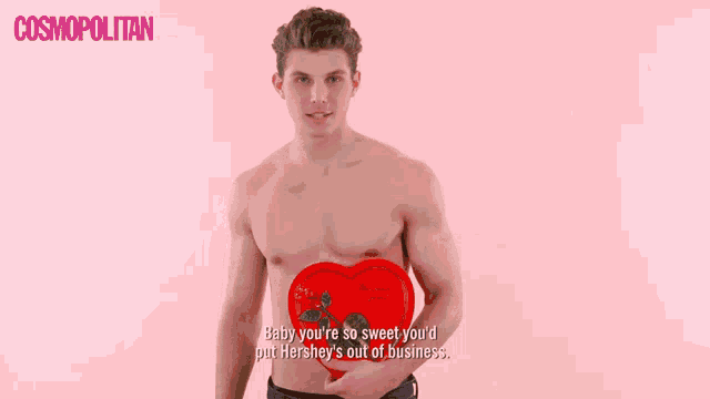 a shirtless man is holding a heart shaped box that says baby