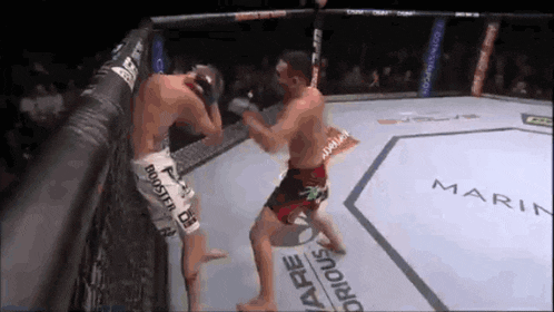 two men are fighting in a boxing ring and one of them is wearing shorts that say booster oil