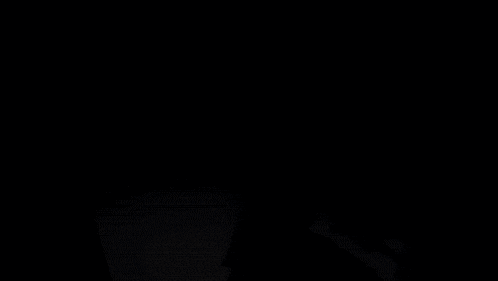 a silhouette of a person with their arms outstretched in a dark room