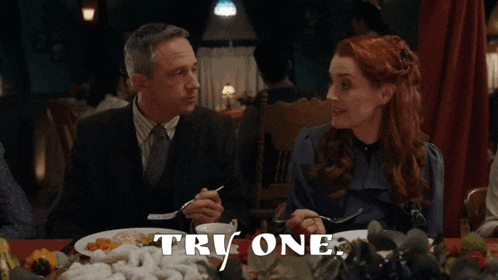 a man and a woman are sitting at a table eating food with the words tri one written on the bottom