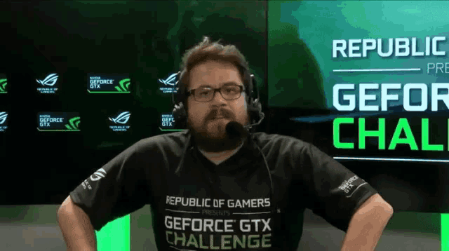 a man wearing a republic of gamers geforce gtx challenge shirt stands with his hands on his hips