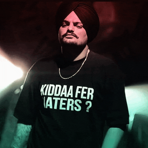 a man in a turban is wearing a black shirt that says kiddaa fer haters