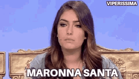 a woman is sitting in a chair with the words maronna santa on her face