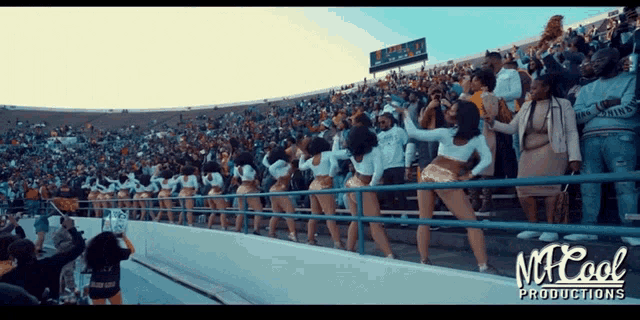 cheerleaders are dancing in a stadium sponsored by mr cool productions