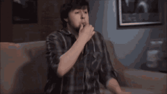 a man with a beard is eating a piece of food .