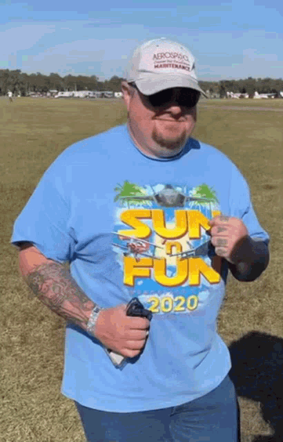 a man wearing a blue shirt that says ' sun fun 2020 ' on it