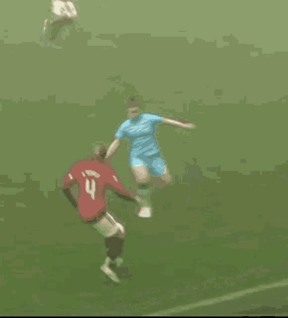 a soccer player with the number 2 on his jersey kicks the ball