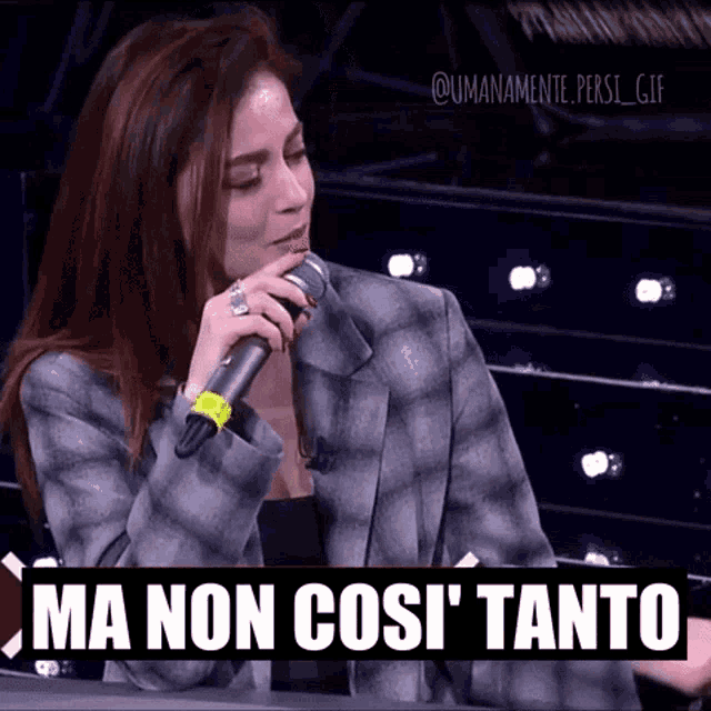 a woman is singing into a microphone with the words ma non cos ' tanto written below her