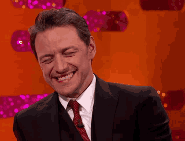 a man in a suit and tie is smiling