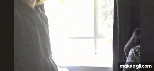 a man is standing in front of a window looking out .