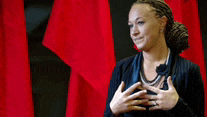 a woman is standing in front of a red curtain with her hands on her chest