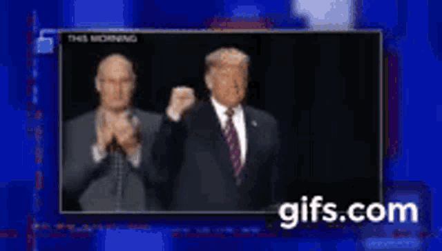 two men in suits and ties are clapping in front of a screen that says this morning