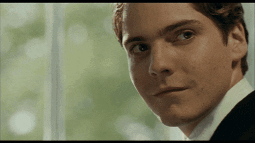 a close up of a man 's face in a suit and tie