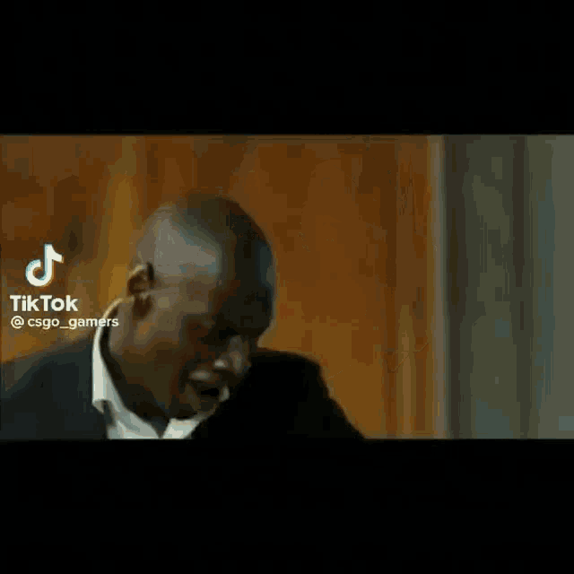 a man in a suit is dancing with his arms outstretched in a room .