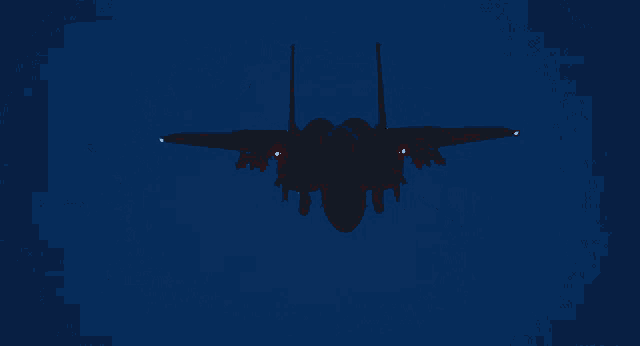 a fighter jet is flying through a dark blue sky at night