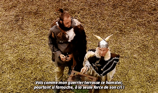 a man in a viking costume stands next to another man in a cage