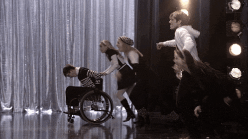 a man in a wheelchair is being pulled by two women
