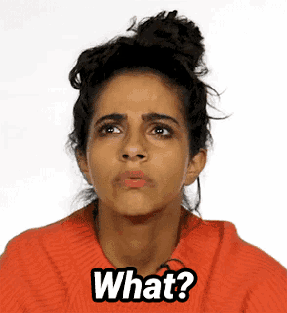 a woman in an orange sweater is making a funny face and says what