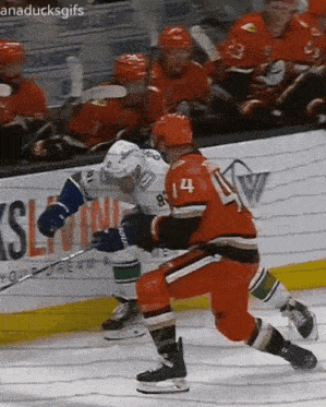 a hockey game is being played in front of a sign that says anaducksgifs