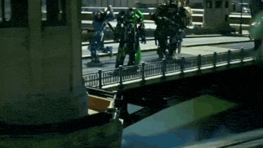 a group of transformers are standing on a bridge