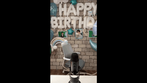 a person in a fairy costume is standing in front of a microphone with balloons in the background .