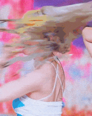 a woman in a blue top is dancing in front of a large screen .