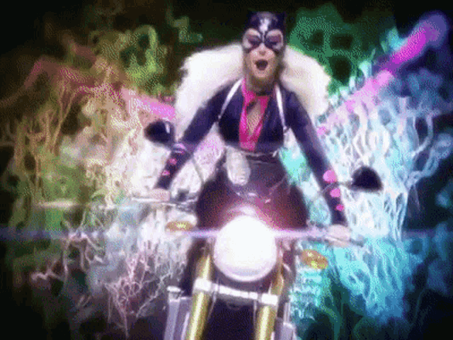 a woman in a cat costume is riding a motorcycle in front of a colorful background