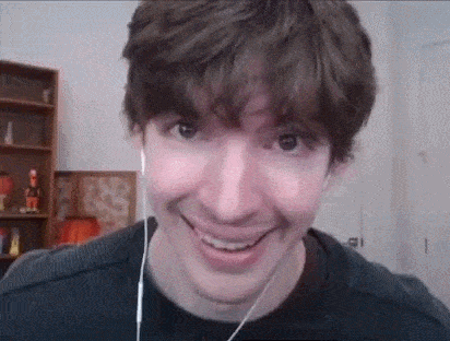 a man wearing headphones is smiling for the camera .