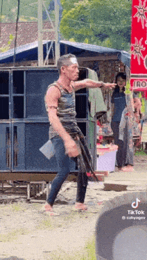 a man with a bandage on his forehead is walking in front of a store .