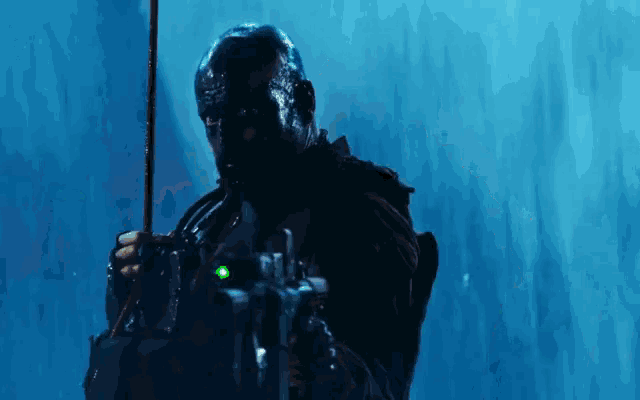 a man in a mask is holding a rifle in the water