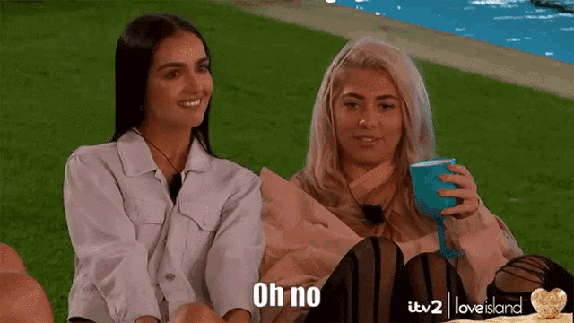 two women are sitting next to each other and one of them is holding a wine glass and the other is saying " oh no "