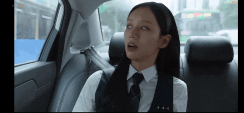 a girl sitting in the back seat of a car